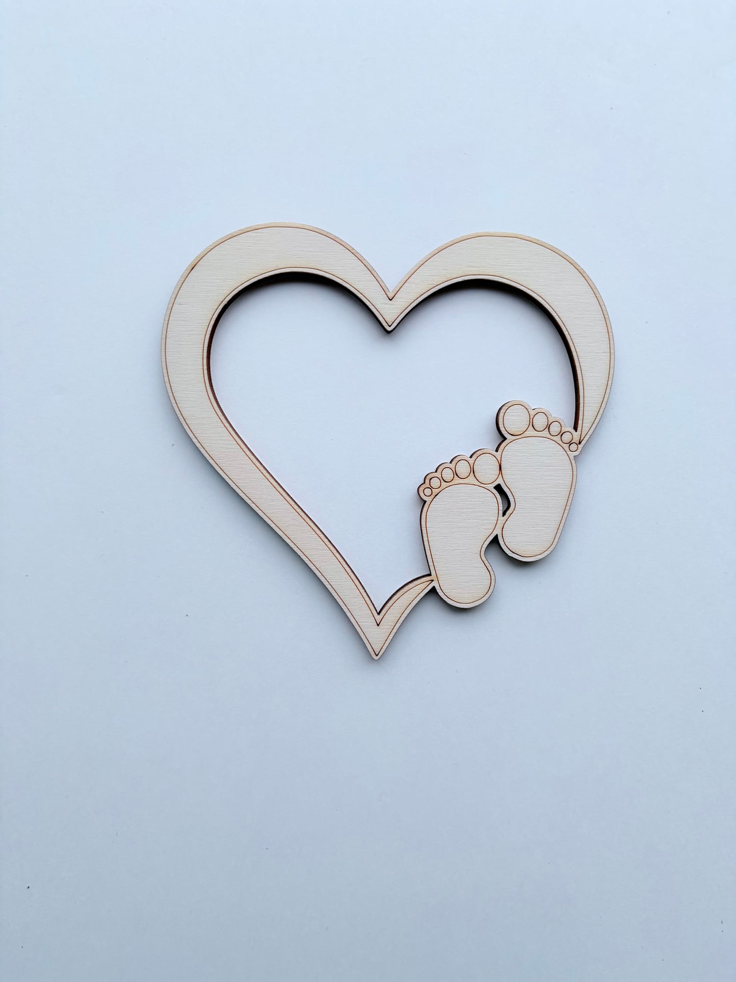 Houten hartdecoratie met babyvoetjes